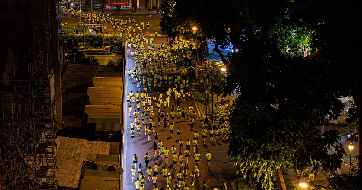 Corredores con camisetas amarillas en una carrera nocturna