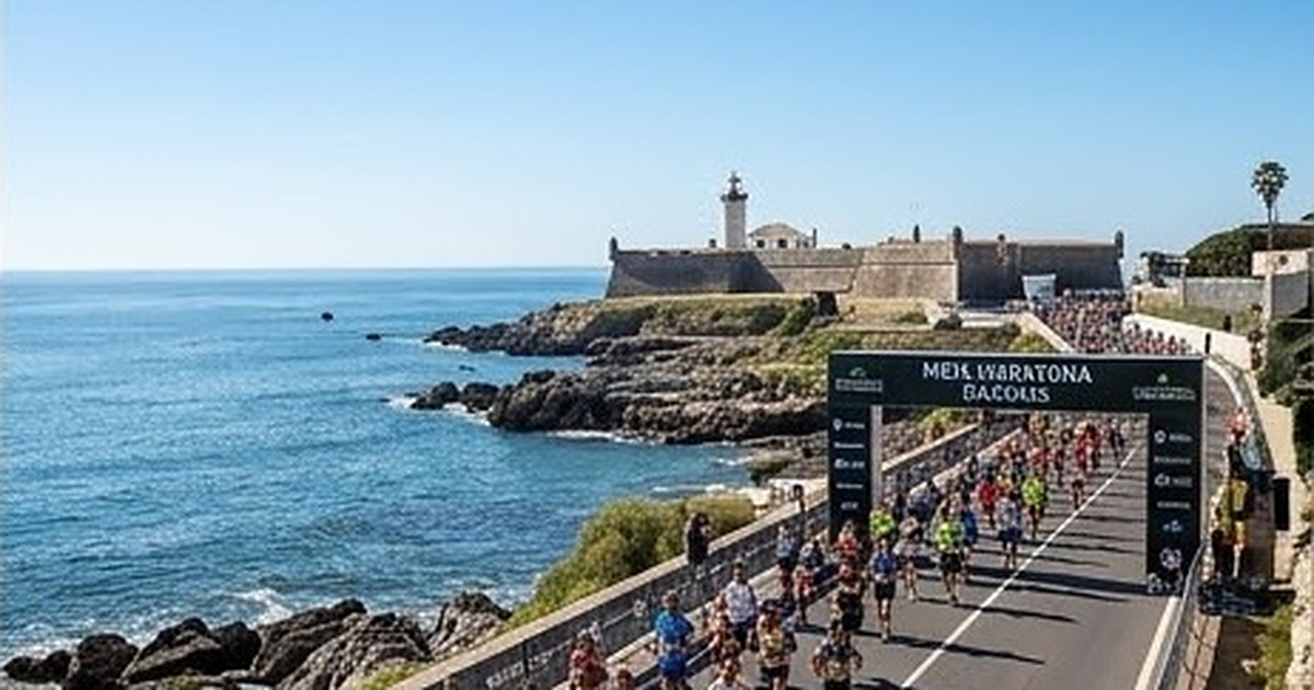Corredores en una carretera junto al mar, con un fuerte al fondo