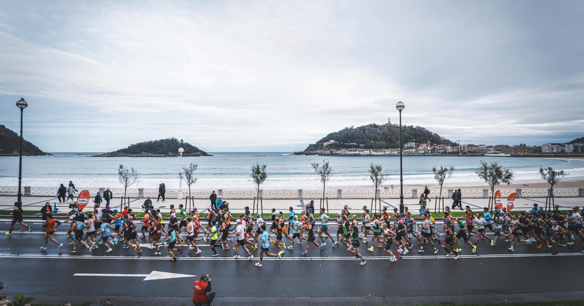 Corredores del maratón de San Sebastián junto a la playa de La Concha, con la isla de Santa Clara al fondo
