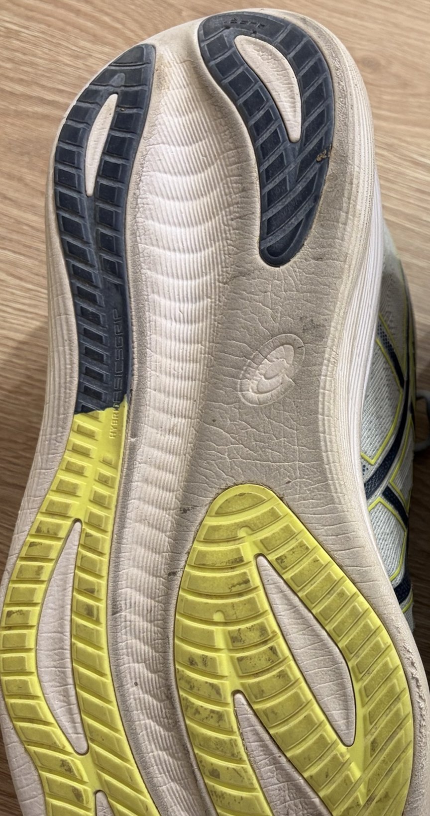 Suela de una ASICS Gel Nimbus 27 después de 600 km, con el compuesto Hybrid ASICSGRIP en azul y amarillo