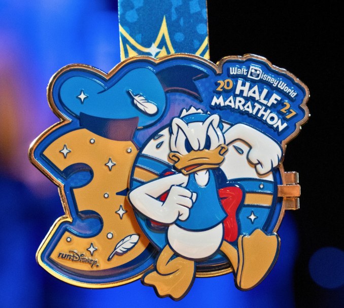 Medalla de la media maratón de Walt Disney World 2027 con Donald Duck corriendo
