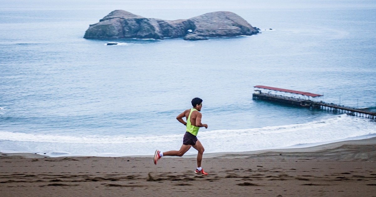 Corredor con chaleco amarillo junto al mar