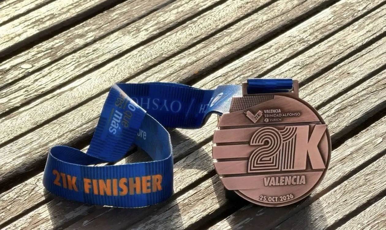 Medalla 21K Finisher del Medio Maratón Valencia Trinidad Alfonso Zurich 2026, con cinta azul, junto a la medalla de acabado cobrizo y la fecha 25 OCT 2026